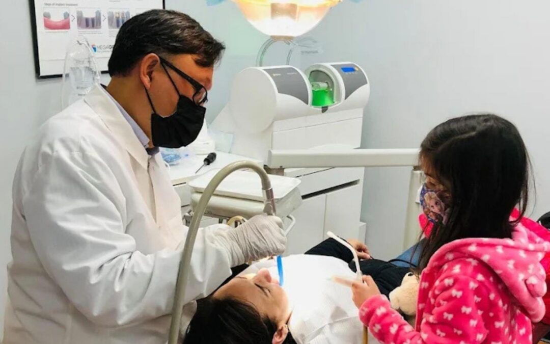 dr song working on a patient with a child helping