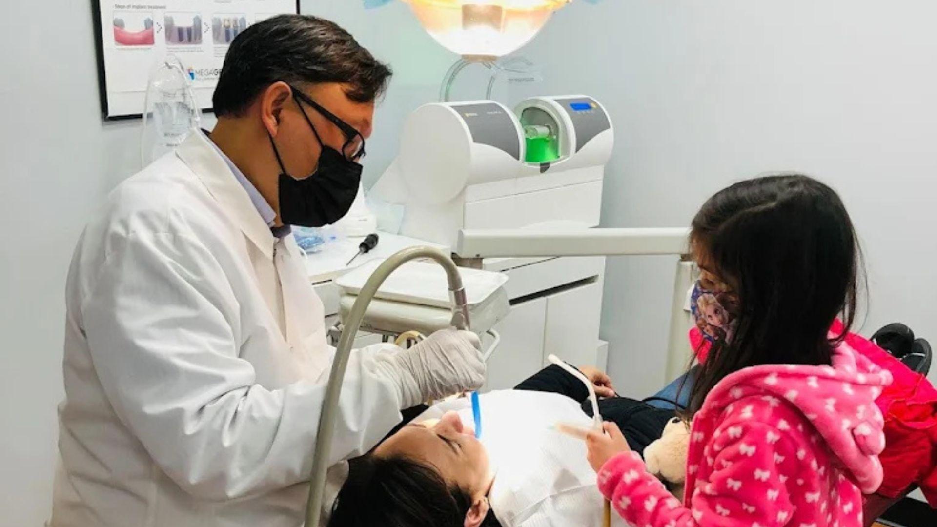 dr song working on  a patient with a child helping