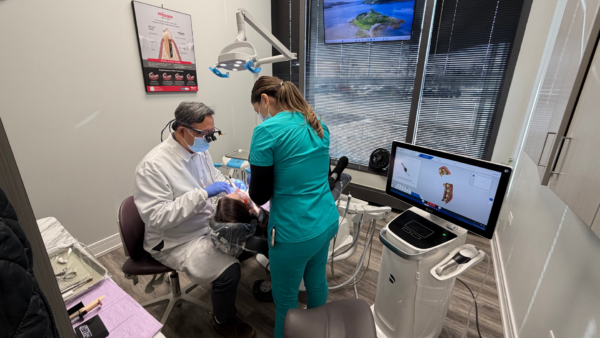 dr song and dental hygienist working on patient 
